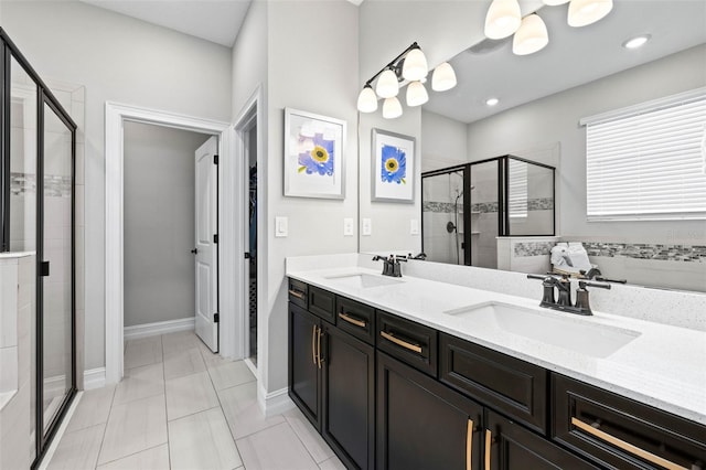 full bath with a stall shower, double vanity, and baseboards