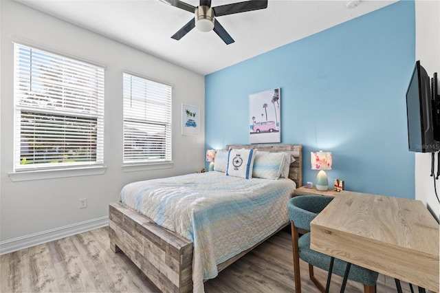 bedroom with wood finished floors, baseboards, and a ceiling fan