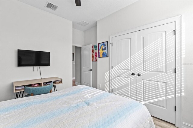 bedroom featuring light wood-type flooring, a closet, and ceiling fan
