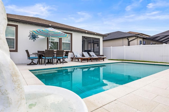 view of pool with fence, a patio, and a sunroom