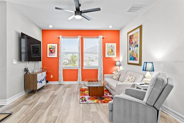 living room with wood finished floors, ceiling fan, and baseboards
