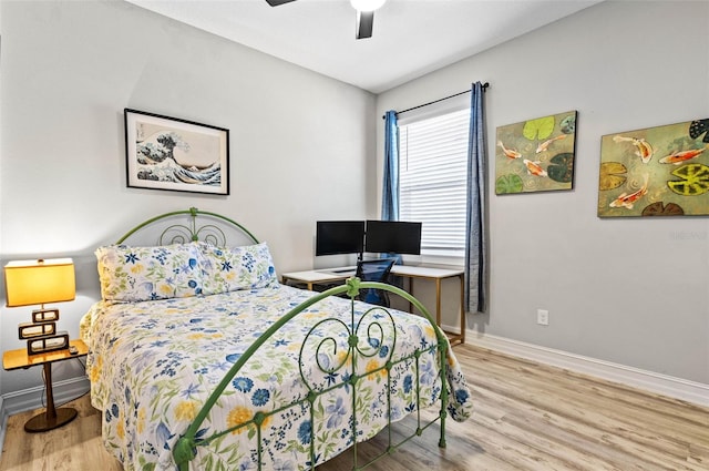 bedroom featuring wood finished floors, baseboards, and a ceiling fan