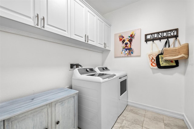 clothes washing area with independent washer and dryer, cabinet space, and baseboards