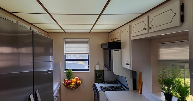 kitchen with range with gas cooktop, light countertops, and freestanding refrigerator