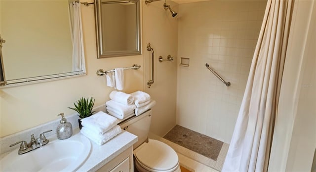 full bathroom with toilet, tiled shower, and vanity