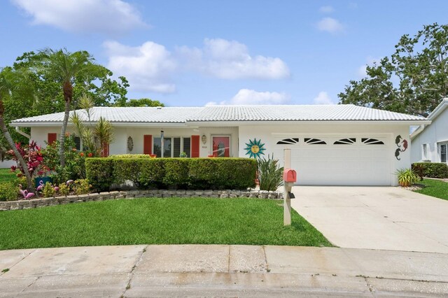 9018 39th Ln N Unit 5, Pinellas Park, FL 33782 - ranch-style house with a garage, a tile roof, a front lawn, driveway, and stucco siding