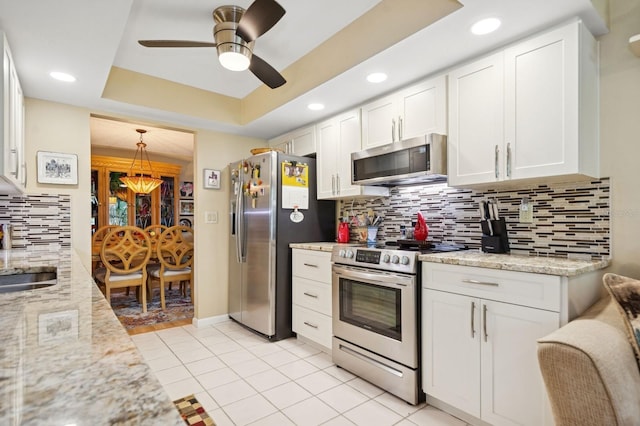 9018 39th Ln N Unit 5, Pinellas Park, FL 33782 - kitchen featuring stainless steel appliances, white cabinets, backsplash, light stone countertops, and light tile patterned floors