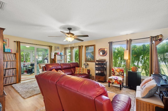 9018 39th Ln N Unit 5, Pinellas Park, FL 33782 - living room with a ceiling fan, a textured ceiling, and light wood-type flooring