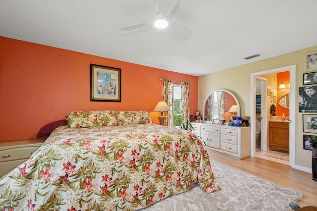 9018 39th Ln N Unit 5, Pinellas Park, FL 33782 - bedroom with wood finished floors, ceiling fan, and ensuite bath
