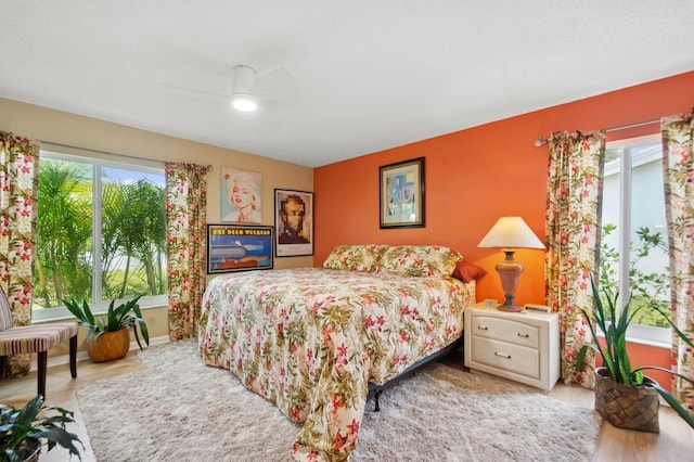 9018 39th Ln N Unit 5, Pinellas Park, FL 33782 - bedroom with multiple windows, wood finished floors, and a ceiling fan