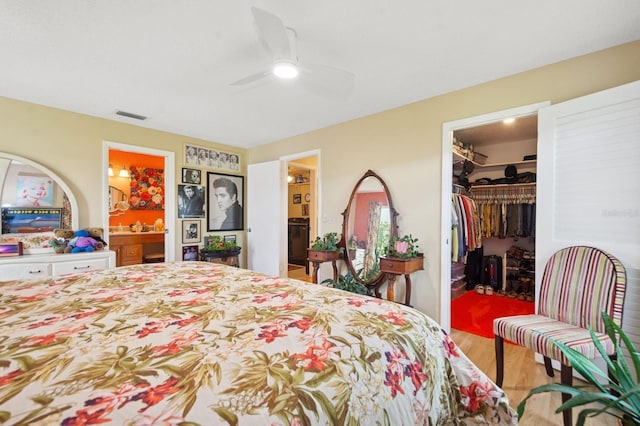 9018 39th Ln N Unit 5, Pinellas Park, FL 33782 - bedroom featuring a walk in closet, wood finished floors, a closet, connected bathroom, and ceiling fan