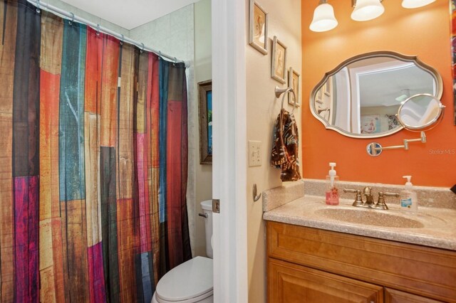 9018 39th Ln N Unit 5, Pinellas Park, FL 33782 - bathroom with toilet, vanity, and a shower with shower curtain