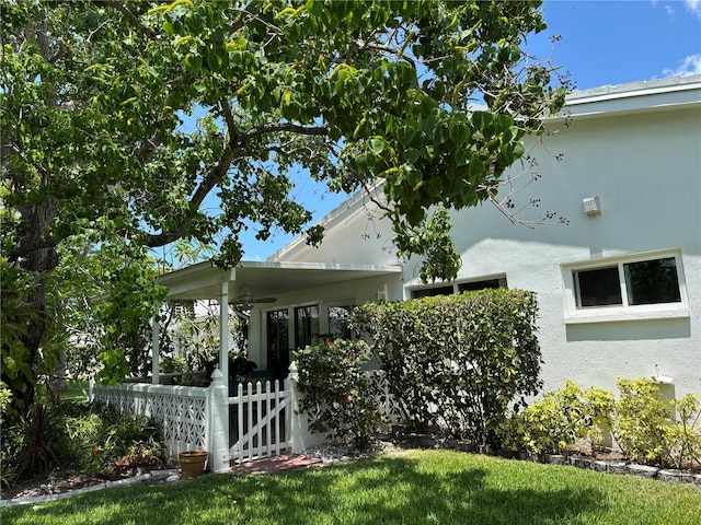9018 39th Ln N Unit 5, Pinellas Park, FL 33782 - view of side of home with stucco siding, fence, and covered porch