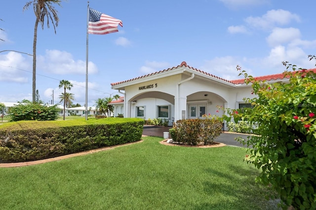 9018 39th Ln N Unit 5, Pinellas Park, FL 33782 - rear view of house with a lawn, stucco siding, and a tiled roof