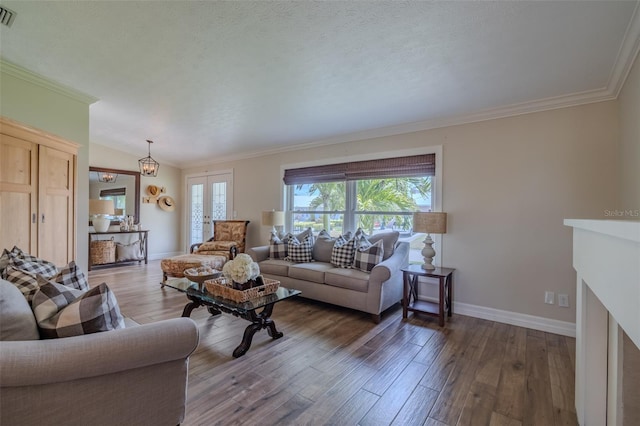 living room featuring healthy amount of natural light, wood finished floors, baseboards, and crown molding