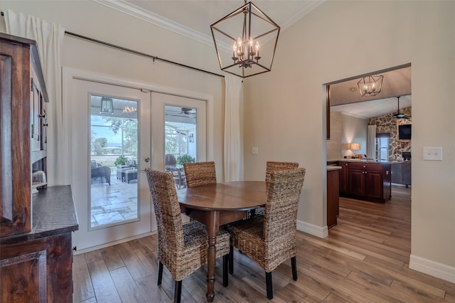 dining area featuring crown molding, light wood finished floors, a chandelier, and baseboards