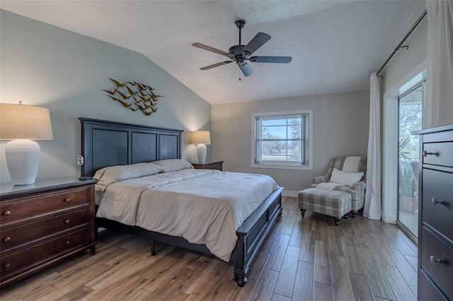 bedroom with lofted ceiling, wood finished floors, access to outside, ceiling fan, and baseboards