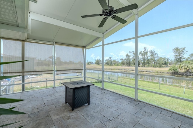 unfurnished sunroom with a water view, ceiling fan, and vaulted ceiling