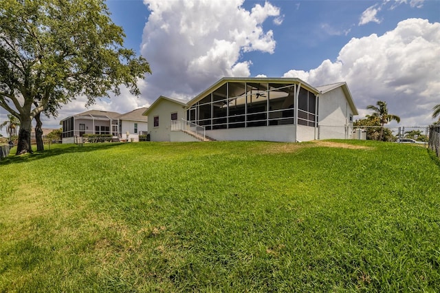 back of property featuring a sunroom and stucco siding