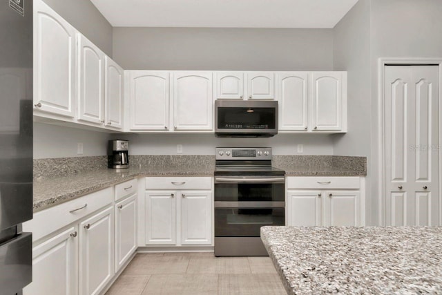 2823 Banyan Hill Ln, Land O Lakes, FL 34639 - kitchen featuring stainless steel appliances, white cabinetry, and light stone counters
