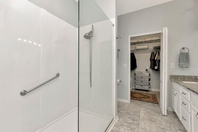 2823 Banyan Hill Ln, Land O Lakes, FL 34639 - bathroom with a walk in shower, vanity, a spacious closet, and baseboards