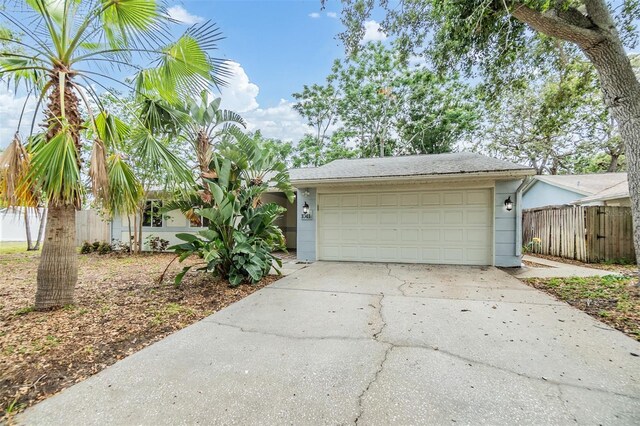 1041 Forest Grove Blvd, Palm Harbor, FL 34683 - view of front facade with driveway, fence, and stucco siding