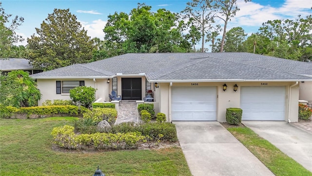 single story home with stucco siding, a front lawn, roof with shingles, and a garage