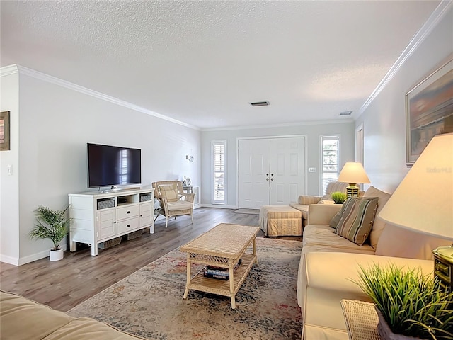 living area with wood finished floors, crown molding, baseboards, and a textured ceiling