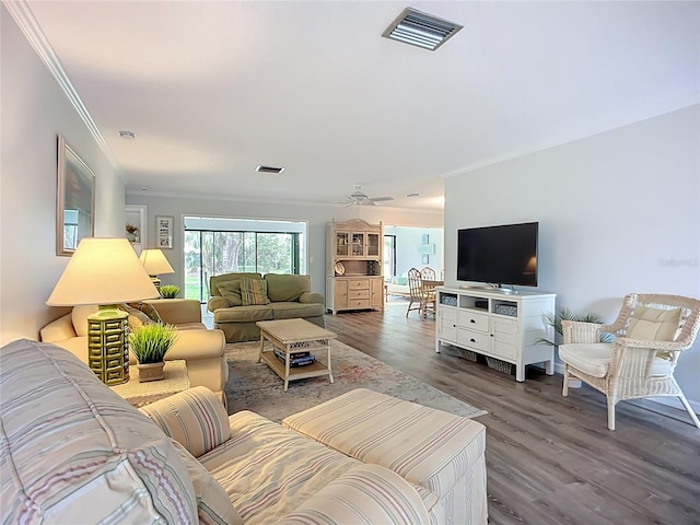 living area with ornamental molding, wood finished floors, and ceiling fan