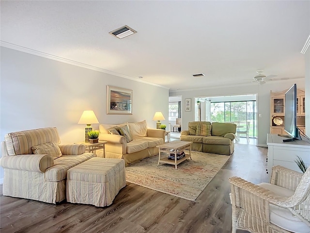 living room with ornamental molding, wood finished floors, and ceiling fan