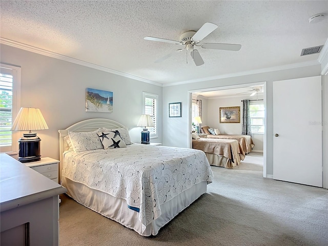 bedroom with crown molding, light carpet, ceiling fan, and a textured ceiling