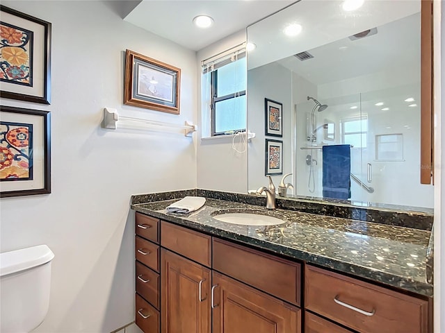 full bathroom featuring a stall shower, toilet, and vanity