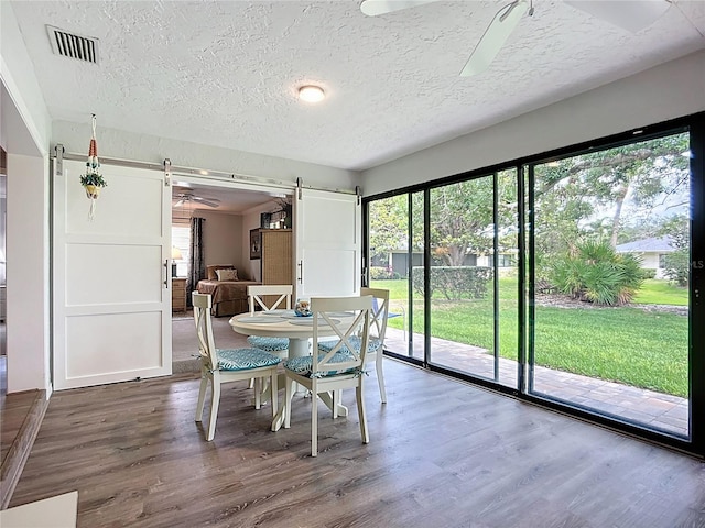 dining room featuring a ceiling fan, wood finished floors, and a textured ceiling