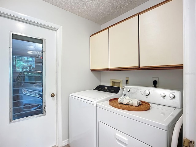 clothes washing area featuring cabinet space, washer and clothes dryer, and a textured ceiling