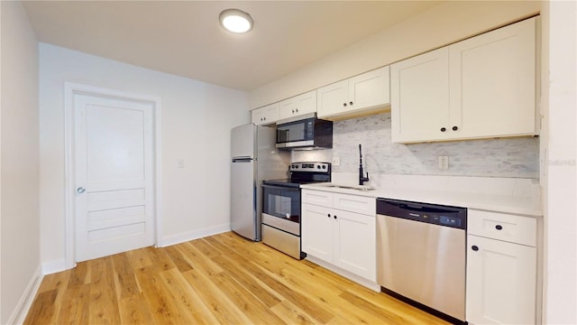 6710 S Juanita St, Tampa, FL 33616 - kitchen with a sink, white cabinetry, decorative backsplash, light countertops, and appliances with stainless steel finishes