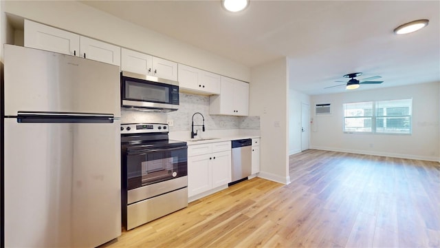 6710 S Juanita St, Tampa, FL 33616 - kitchen featuring stainless steel appliances, light wood finished floors, a sink, light countertops, and tasteful backsplash
