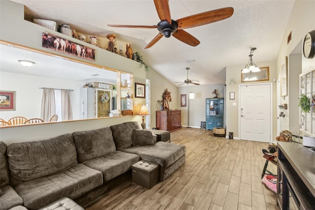 living room featuring ceiling fan, light wood-type flooring, lofted ceiling, healthy amount of natural light, and a chandelier