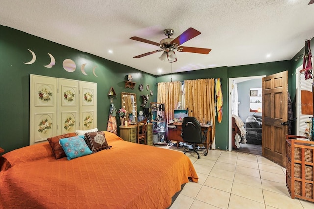 bedroom with light tile patterned flooring, a desk, a textured ceiling, and a ceiling fan