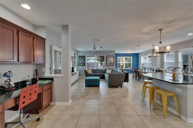 5914 Goldenbark Pl, Lithia, FL 33547 - kitchen with stainless steel fridge, a breakfast bar, open floor plan, pendant lighting, and ceiling fan