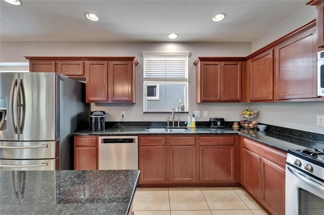 5914 Goldenbark Pl, Lithia, FL 33547 - kitchen with stainless steel appliances, a sink, dark stone countertops, light tile patterned floors, and brown cabinets