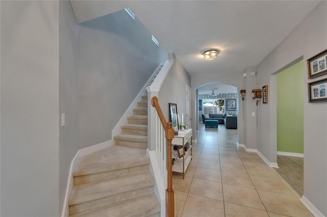 5914 Goldenbark Pl, Lithia, FL 33547 - staircase featuring arched walkways, tile patterned floors, and baseboards