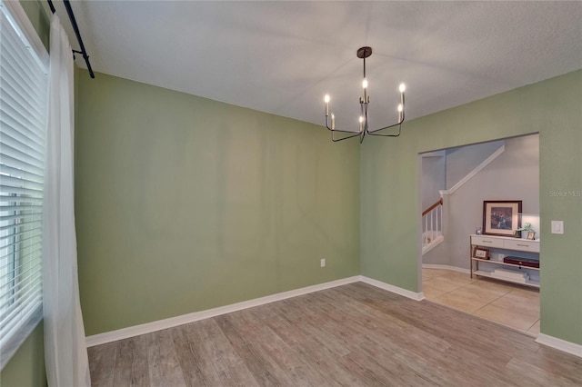 5914 Goldenbark Pl, Lithia, FL 33547 - unfurnished room featuring a chandelier, wood finished floors, stairs, and baseboards