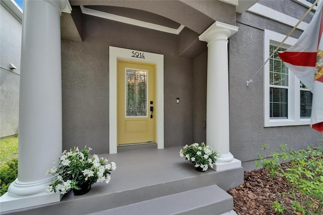 5914 Goldenbark Pl, Lithia, FL 33547 - view of exterior entry featuring stucco siding and a porch