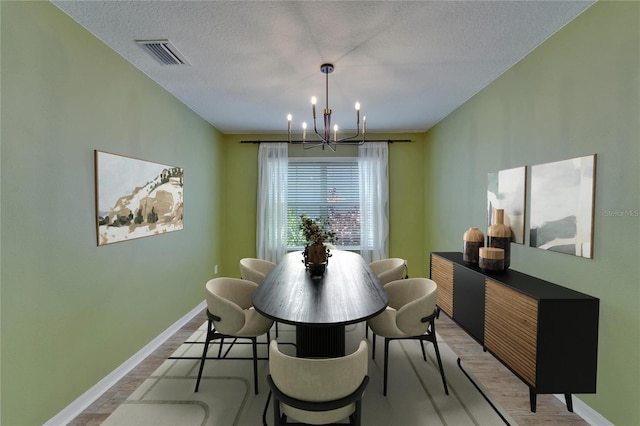 5914 Goldenbark Pl, Lithia, FL 33547 - dining area featuring a chandelier, light wood-style floors, baseboards, and a textured ceiling