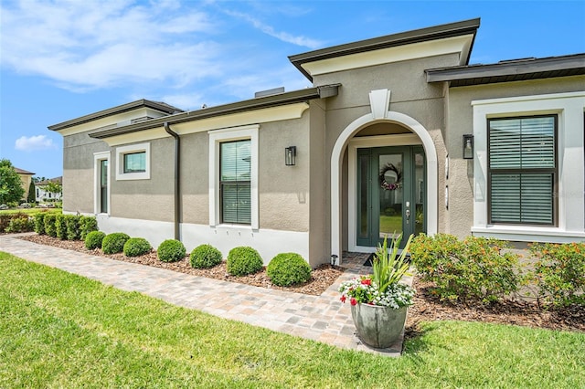 4329 Barletta Ct, Wesley Chapel, FL 33543 - view of exterior entry with stucco siding and a lawn