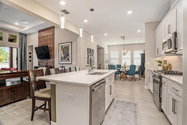 4329 Barletta Ct, Wesley Chapel, FL 33543 - kitchen featuring stainless steel appliances, a sink, healthy amount of natural light, a kitchen bar, and recessed lighting