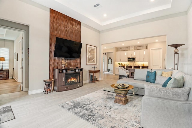 4329 Barletta Ct, Wesley Chapel, FL 33543 - living room with recessed lighting, baseboards, a raised ceiling, and a lit fireplace