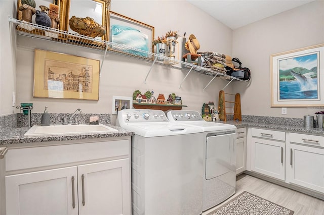 4329 Barletta Ct, Wesley Chapel, FL 33543 - washroom featuring washing machine and dryer, cabinet space, and light wood-style flooring