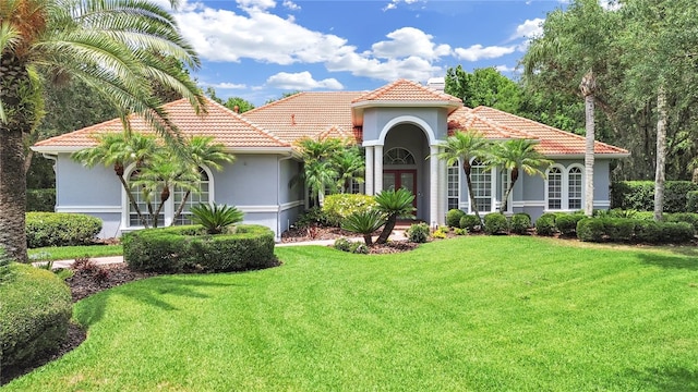 16343 Burniston Dr, Tampa, FL 33647 - mediterranean / spanish house featuring a tile roof, french doors, a front lawn, and stucco siding