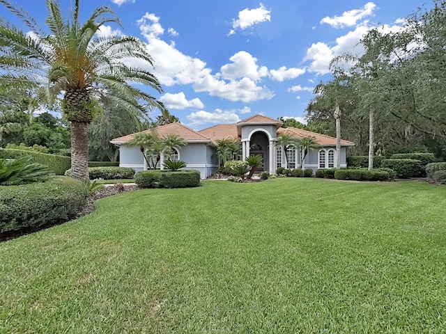 16343 Burniston Dr, Tampa, FL 33647 - mediterranean / spanish-style home with a front lawn and stucco siding